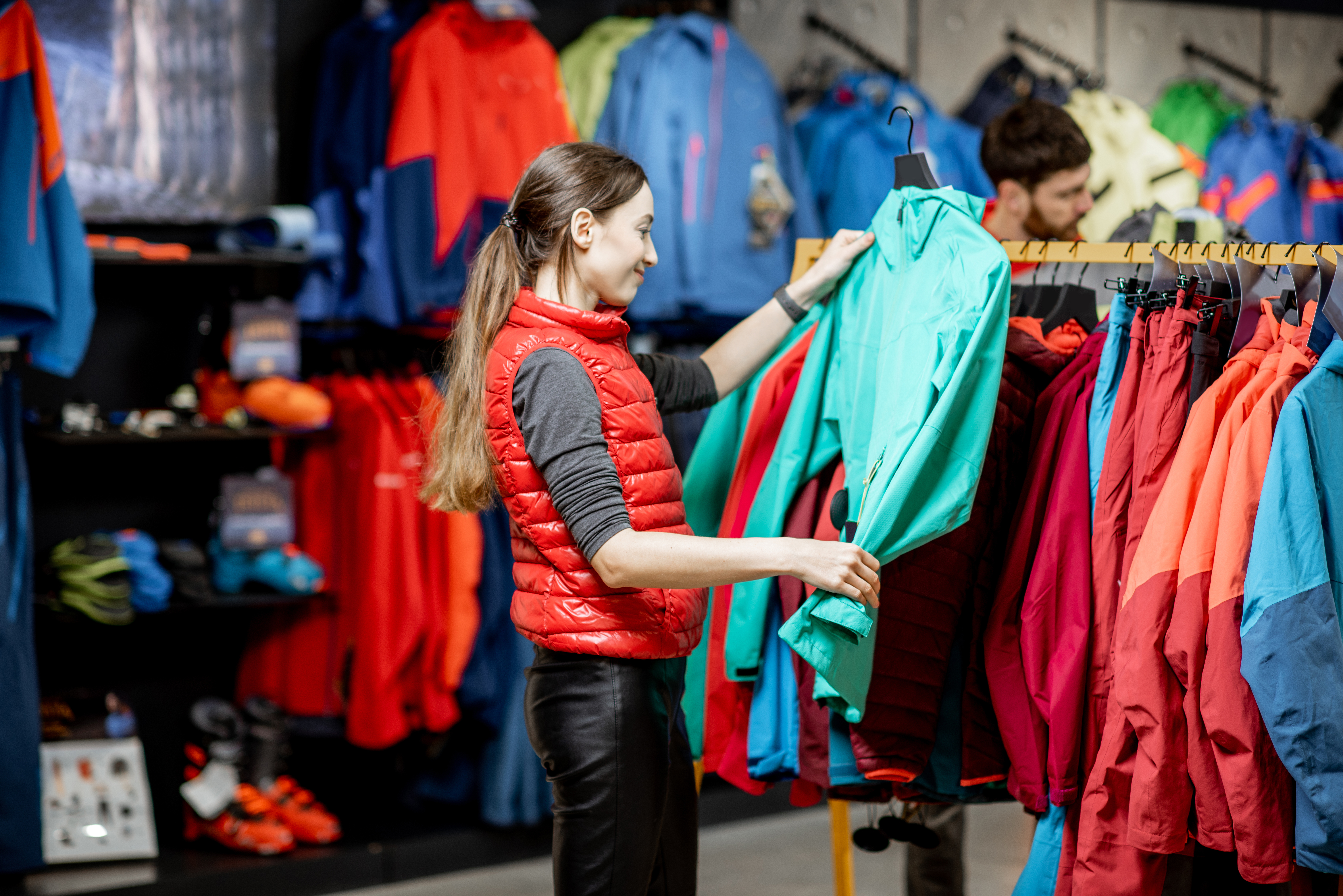 A woman holding and examining a garment from a rack
