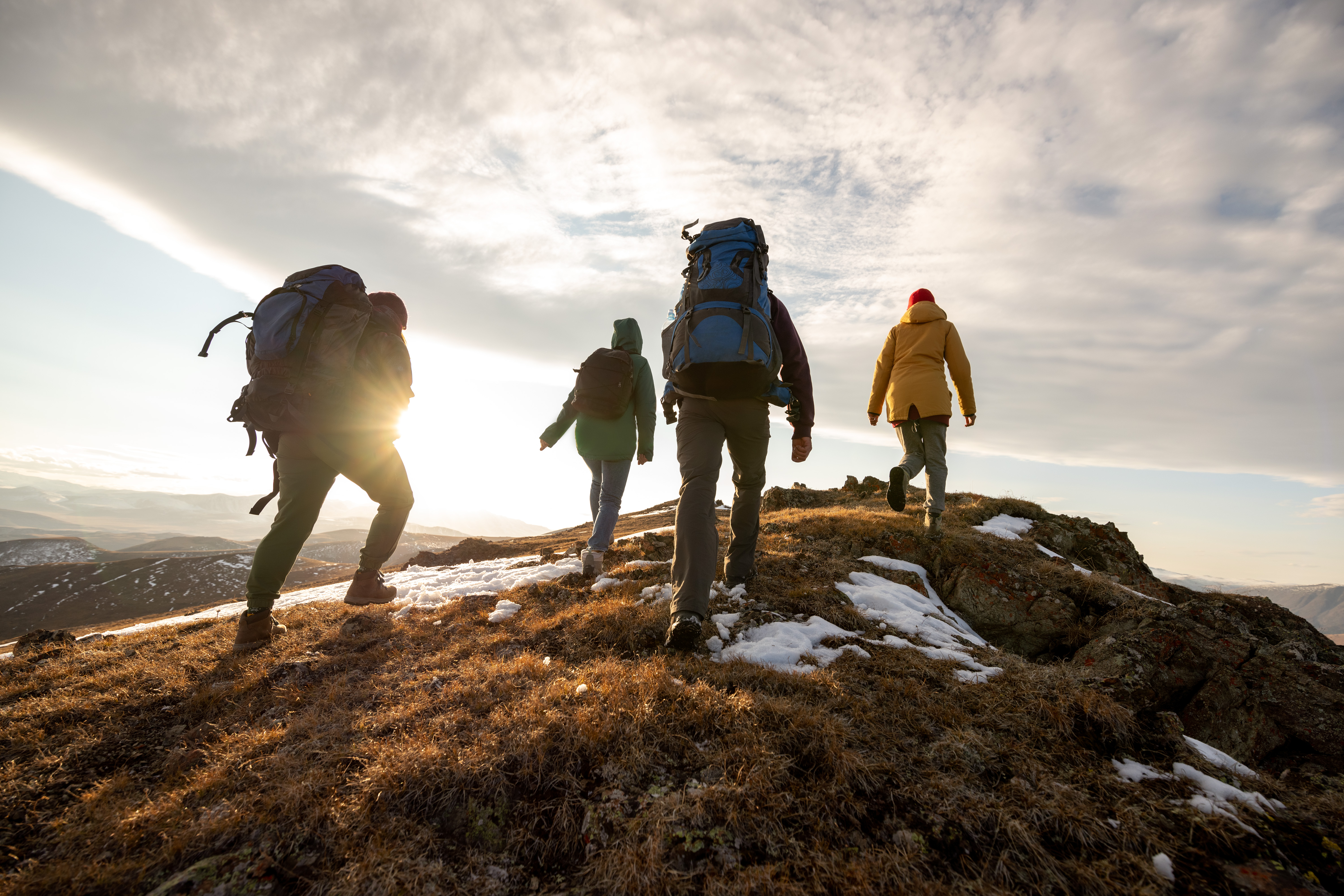 Four hikers walking over a hill